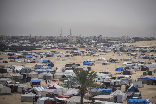 Palestinians displaced by the Israeli air and ground offensive on the Gaza Strip walk through a makeshift tent camp in Rafah, Gaza, Friday, May 10, 2024. (AP Photo/Abdel Kareem Hana)