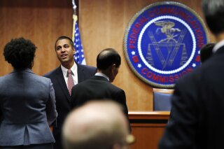 
              Federal Communications Commission (FCC) Chairman Ajit Pai, left, greets witnesses before a meeting where the FCC will vote on net neutrality, Thursday, Dec. 14, 2017, in Washington. (AP Photo/Jacquelyn Martin)
            