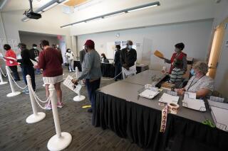 FILE - Early voters line up to cast their ballots inside the South Regional Library polling location in Durham, N.C., Thursday, Oct. 15, 2020. After receiving more than a dozen reports of conduct violations by party-appointed poll watchers during the May primaries in North Carolina, the state elections board tightened regulations for precinct observers on Tuesday, Au. 16, 2022, to prevent partisan interference in the November general election. (AP Photo/Gerry Broome, File)