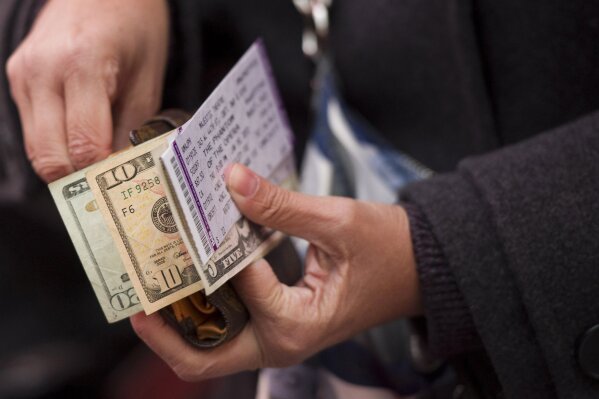 FILE - This Jan. 19, 2012 file photo shows a theatergoer buying Broadway tickets in New York. Broadway’s hardcore fan base is taking advantage of a somewhat uncelebrated loyalty plan called Audience Rewards, a sort of frequent flyer program for theater fans. (AP Photo/Charles Sykes, File)