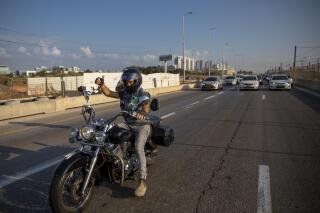 Una caravana de autos ralentiza el tráfico en una protesta contra las restricciones asociadas al coronavirus impuestas por el Ministerio israelí de Salud, en la autopista de Ayalon, en Tel Aviv, Israel, el domingo 3 de octubre de 2021. (AP Foto/Oded Balilty)