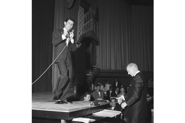 FILE - Eddie Fisher uses the top of a grand piano as a stage to entertain 500 Las Vegans in a local preview debut of his first Las Vegas appearance, April 1957. He will formally open the new Hotel Tropicana with a cast of 50 performers. (AP Photo, File)