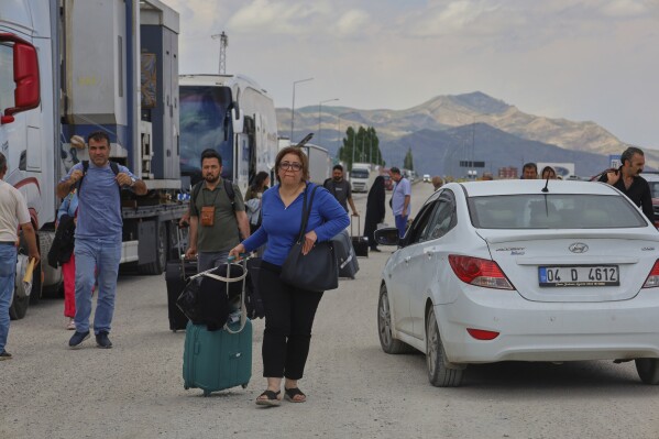 Iranians arrive to cross into Iran at Gurbulak Bazargan border post, in Gurbulak, Turkey, Monday, June 16, 2025. (AP Photo/Kadir Cesur)