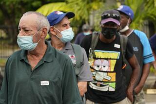 Todd Dowd, foreground, waits in line to receive the Johnson & Johnson vaccine, Thursday, May 13, 2021, at a mobile vaccination site at the Greater Bethel Church in Miami. The Miami-Dade County Homeless Trust and the Florida Division of Emergency Management partnered to provide the one-dose vaccine at unsheltered homeless hotspots and shelters across the county. (AP Photo/Wilfredo Lee)