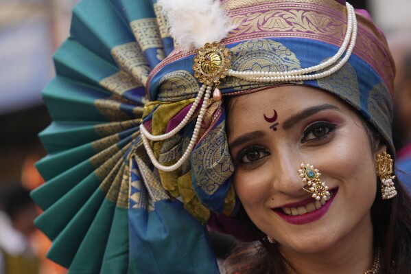 A woman dressed in traditional attire smiles during a procession marking Gudi Padwa or the Marathi New Year, in Mumbai, India, April 9, 2024.(AP Photo/Rajanish Kakade)