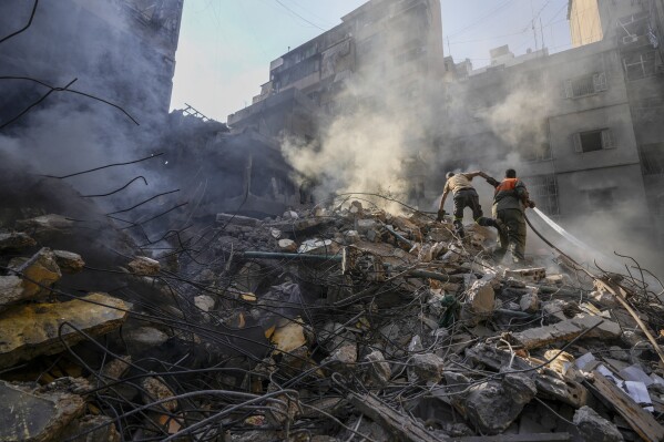 FILE - Rescue workers search for victims at the site of Thursday's Israeli airstrike in Beirut, Lebanon, Friday, Oct. 11, 2024. (AP Photo/Hassan Ammar, File)