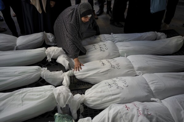 Palestinians mourn their relatives killed in the Israeli bombardment of the Gaza Strip, outside a morgue in Rafah, southern Gaza, Wednesday, Jan. 10, 2024. (AP Photo/Fatima Shbair)