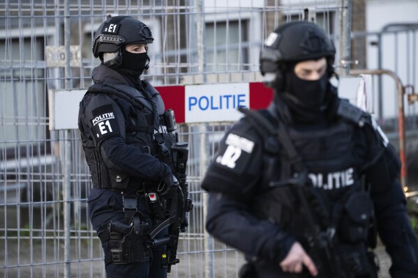 Police secure the area as vehicle carrying suspects arrives at the high security court in Amsterdam, Netherlands, Tuesday, Feb. 27, 2024, where judges are to rule in the Marengo case, one of the largest trials in Dutch history with seventeen defendants accused of participation in a criminal organization and of involvement in 6 murders and 4 attempted murders. (AP Photo/Peter Dejong)