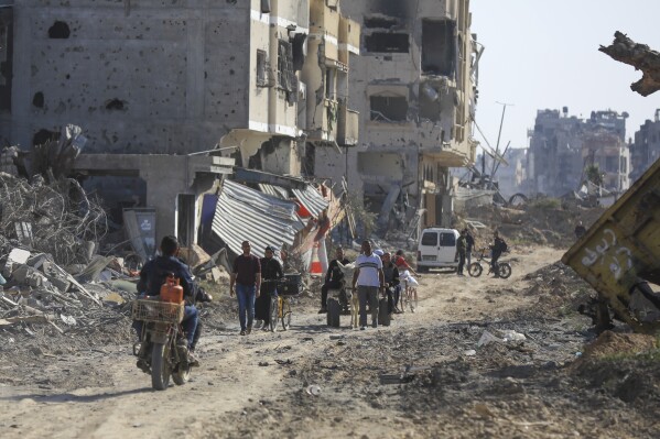 2024年4月7日日曜日、ガザ地区南部のハーンユニスから撤退後、イスラエルの空軍と地上攻撃による荒廃の中を歩くパレスチナ人たち（AP写真/イスマエル・アブ・デイヤ）
