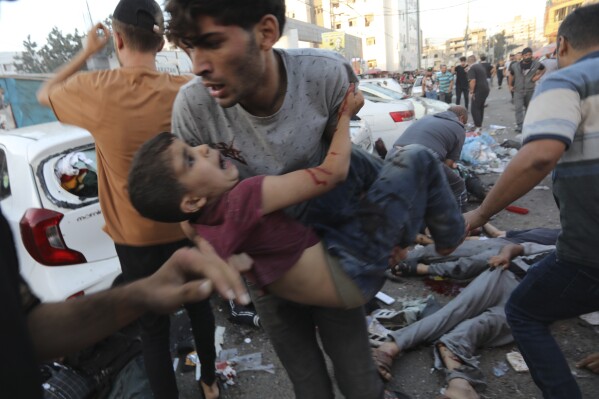 An injured Palestinian boy is carried from the ground following an Israeli airstrike outside the entrance of the al-Shifa hospital in Gaza City, Friday, Nov. 3, 2023. (AP Photo/Abed Khaled)