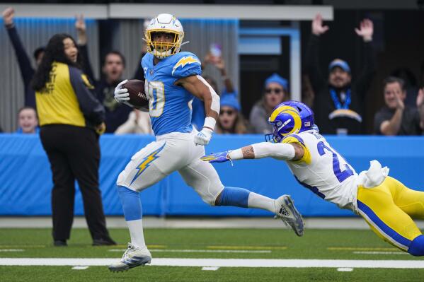 Los Angeles Chargers running back Austin Ekeler (30) evades a tackle from Los Angeles Rams safety Taylor Rapp as he runs toward the end zone for a touchdown during the first half of an NFL football game Sunday, Jan. 1, 2023, in Inglewood, Calif. (AP Photo/Mark J. Terrill)
