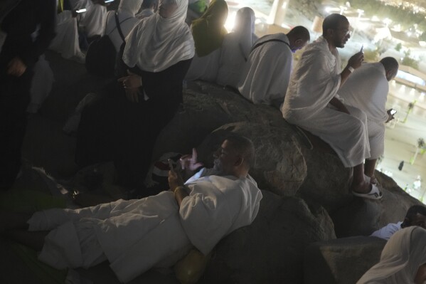 Muslim pilgrims pray on the rocky hill known as the Mountain of Mercy on the Plain of Arafat during the annual Hajj pilgrimage near the holy city of Mecca, Saudi Arabia, Thursday, June 5, 2025. (AP Photo/Amr Nabil)
