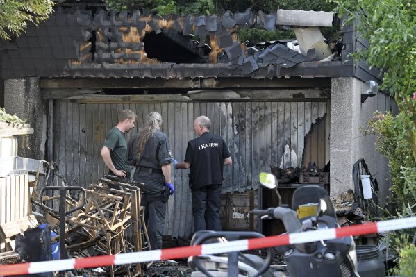 
              Police investigate in a garage Tuesday, May 30, 2017, where an explosion happened Monday afternoon Monday afternoon in the town of Hennef, western Germany. Police said the neighborhood was evacuated after World War II-era grenades and other munitions bought at a flea market began exploding in summer-like heat. (Henning Kaiser/dpa via AP)
            