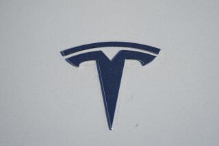 FILE - in this Sunday, Jan. 24, 2021, file photo, the company logo shines off the hood of an unsold 2021 Model 3 sedan at a Tesla dealership, in Littleton, Colo. Two key groups that offer automobile safety ratings have yanked their top endorsements of some Tesla vehicles because the company has stopped using radar on its safety systems. (AP Photo/David Zalubowski, File)