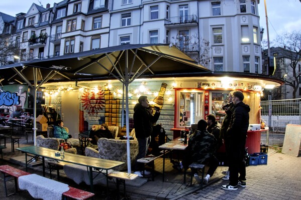 People gather at a former water house, a small shop that sprung up in the 19th century to encourage workers to drink affordable water rather than beer or schnapps, that is now a kiosk in Frankfurt, Germany, on March 14, 2025. (AP Photo/Michael Probst)