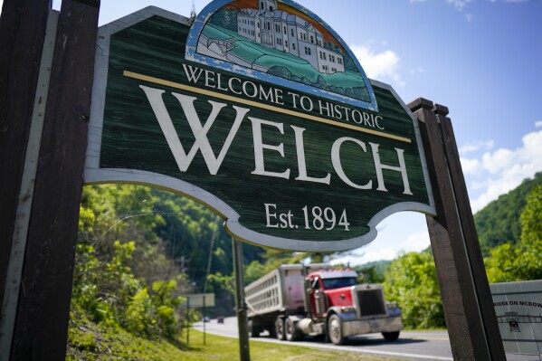 A coal truck drives past the welcome sign on Thursday, June 1, 2023, in Welch, W.Va. In March, the weekly publication in McDowell County one of the poorest counties America became another one of the quarter of all U.S. newspapers that have shuttered since 2005, a crisis Nester called "terrifying for democracy" and one that disproportionately impacts rural America. (AP Photo/Chris Carlson)