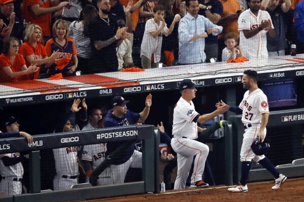 FILE- In this Saturday, Oct. 19, 2019, file photo, Houston Astros second baseman Jose Altuve is greeted at the dugout manager AJ Hinch after scoring on a fielder's choice in the sixth inning in Game 6 of baseball's American League Championship Series against the New York Yankees in Houston. The AL champions have been dogged by allegations of spying, most recently during this year’s ALCS against the Yankees. Houston players were suspected of whistling in the dugout to communicate pitch selection to batters, an allegation manager AJ Hinch called “ridiculous.” (AP Photo/Sue Ogrocki, File)