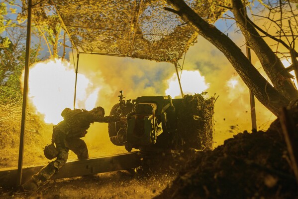 A Ukrainian serviceman of the 10th Assault Brigade Edelweiss fires a D-30 cannon towards Russian positions at the front line, near Bakhmut, Donetsk region, Ukraine, Wednesday, July 5, 2023. (AP Photo/Libkos)