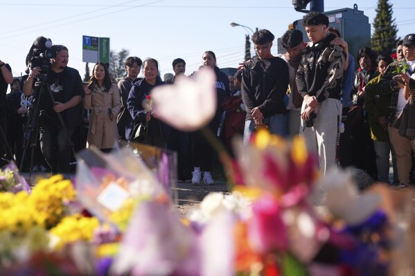 People visit a memorial after a vehicle drove into a crowd during a Filipino heritage festival in Vancouver, British Columbia, Sunday, April 27, 2025. (AP Photo/Lindsey Wasson)