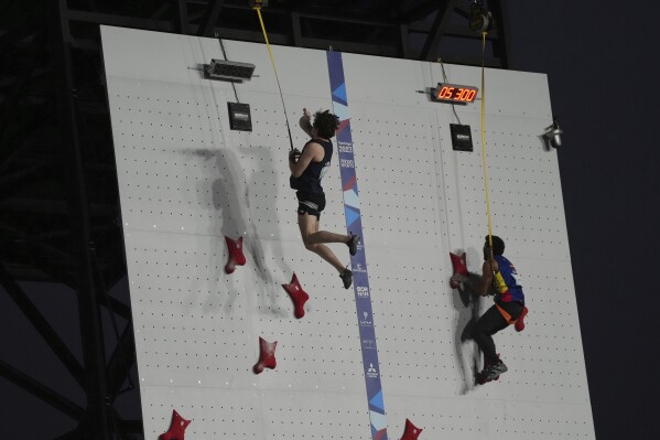 The United States´ Samuel Watson and Ecuador's Isaac Estevez compete in the men's speed sport climbing quarter finals at the Pan American Games in Santiago, Chile, Sunday, Oct. 22, 2023. (AP Photo/Dolores Ochoa)
