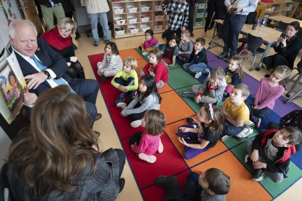Minnesota Gov. Tim Walz, along with Lt. Gov. Peggy Flanagan and first lady Gwen Walz, read "The Day You Began" by Jacqueline Woodson, illustrated by Rafael López, to a group of kindergarteners at Adams Spanish Immersion Elementary, Tuesday, Jan. 17, 2023, St. Paul, Minn. (Glen Stubbe/Star Tribune via AP)