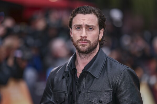 FILE - Aaron Taylor-Johnson poses for photographers upon arrival at the World premiere of the film 'Back To Black' on Monday, April 8, 2024 in London. The latest movie to shift spots for the summer movie season is Sony’s comic book film “Kraven the Hunter,” which will now open in December, instead of Labor Day weekend. The film stars Taylor-Johnson as the Spider-Man villain in the J.C. Chandor-directed origin story. (Photo by Vianney Le Caer/Invision/AP, File)