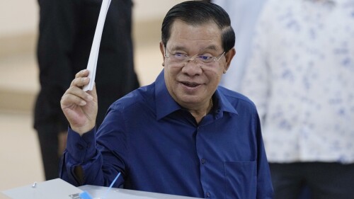FILE- Cambodian Prime Minister Hun Sen of the Cambodian People's Party (CPP) raises a ballot before voting at a polling station at Takhmua in Kandal province, southeast Phnom Penh, Cambodia, on July 23, 2023. Longtime Cambodian leader Hun Sen says he will step down in three weeks as prime minister and hand the position to his oldest son. (AP Photo/Heng Sinith, File)