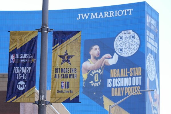Signage promoting the NBA All-Star basketball game is shown in front of mural on the 34 floor tall JW Marriott in Indianapolis, Wednesday, Feb. 14, 2024. The NBA All-Star game in Sunday. (AP Photo/Michael Conroy)