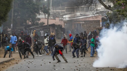 Protesters throw rocks at police during clashes next to a cloud of teargas in the Kibera area of Nairobi, Kenya Wednesday, July 19, 2023. Kenyans were back protesting on the streets of the capital Wednesday against newly imposed taxes and the increased cost of living. (AP Photo/Brian Inganga)