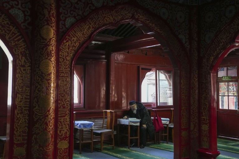 A Muslim reads the Quran while they fast during the first day of Ramadan at the Niujie Mosque in Beijing, China, Tuesday, March 12, 2024. (AP Photo/Tatan Syuflana)