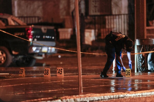Police on the scene of a shooting Monday, July 3, 2023 in Philadelphia. Police say a gunman in a bulletproof vest has opened fire on the streets of Philadelphia, killing several people and wounding two boys before he surrendered to responding officers. (Steven M. Falk/The Philadelphia Inquirer via AP)