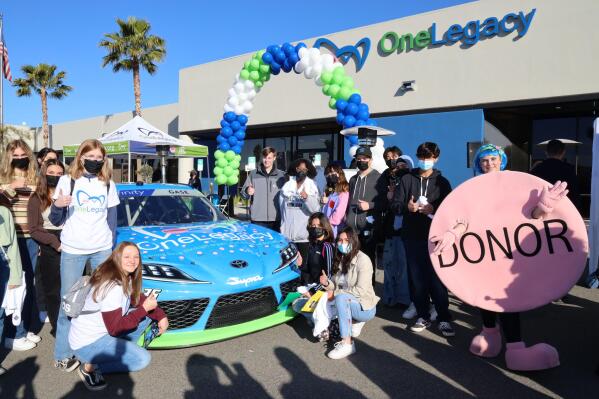 Dozens of students and donor families recently joined with organ, eye and tissue recipients at OneLegacy’s Transplant Recovery Center in Redlands to help decorate NASCAR driver Joey Gase’s racecar with pink donor dots, representing a symbol of hope and support for the 107,000 people around the country who are currently waiting for a lifesaving organ or tissue transplant. (Photo: Business Wire)