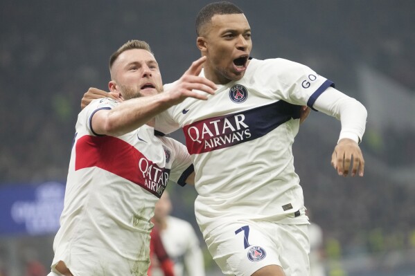 PSG's Milan Skriniar, left, celebrates with his teammate PSG's Kylian Mbappe after scoring his side's opening goal during the Champions League, Group F soccer match between AC Milan and PSG, at the San Siro stadium in Milan, Italy, Tuesday, Nov. 7, 2023. (AP Photo/Luca Bruno)