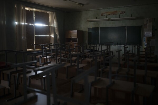The windows of a classroom in a primary school are blocked for protection from shelling in Kupiansk, Ukraine, Wednesday, Aug. 23, 2023. (AP Photo/Bram Janssen)