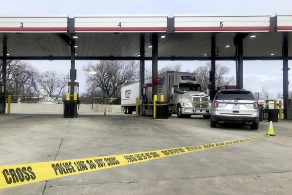 A tractor trailer is stopped behind police tape as law enforcement investigate the scene of a carjacking and shooting at a QuikTrip in St. Peters, Mo., on Wednesday, Dec. 29, 2021. Officials believe the suspect was the same person who fatally shot a sheriff's deputy in Wayne County, Ill., earlier Wednesday, a St. Peters police spokesperson said. (Hillary Levin/St. Louis Post-Dispatch via AP)