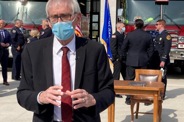 FILE - In this April 27, 2021, file photo, Wisconsin Gov. Tony Evers speaks with media at a news conference in Madison, Wis. Wisconsin will receive $700 million less than initially expected in federal coronavirus relief money and get it in two payments a year apart, news that  Evers and U.S. Sen. Tammy Baldwin said Tuesday, May 11, 2021 was problematic. (AP Photo/Scott Bauer File)