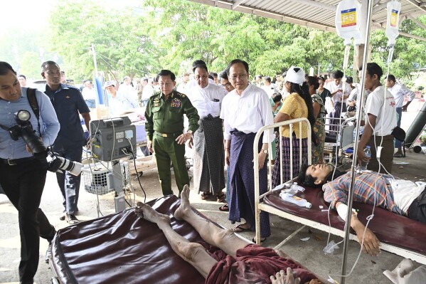 In this image provided by The Myanmar Military True News Information Team, Myanmar's military leader Senior Gen. Min Aung Hlaing, center, inspects victims caused by an earthquake Friday, March 28, 2025, in Naypyitaw, Myanmar. (The Myanmar Military True News Information Team via AP)