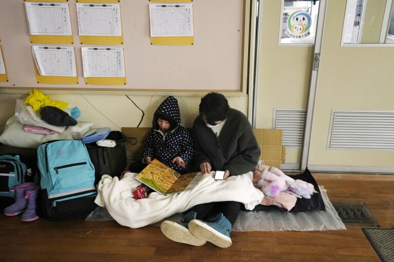 Evacuees rest at a temporary evacuation center in Suzu in the Noto peninsula facing the Sea of Japan, northwest of Tokyo, Wednesday, Jan. 3, 2024, following Monday's deadly earthquake. (AP Photo/Hiro Komae)