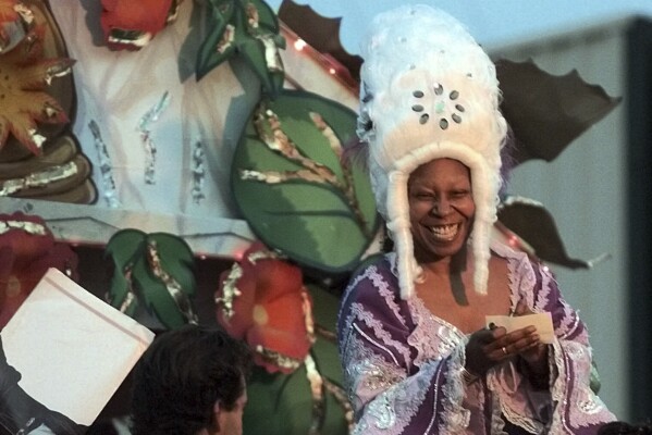 Actress Whoopi Goldberg signs autographs during the Orpheus Mardi Gras parade, March 6, 2000, in New Orleans. Golberg is the celebrity monarch of the carnival krew, founded in 1993 by singer Harry Connick Jr. (AP Photo/Bill Haber, file)