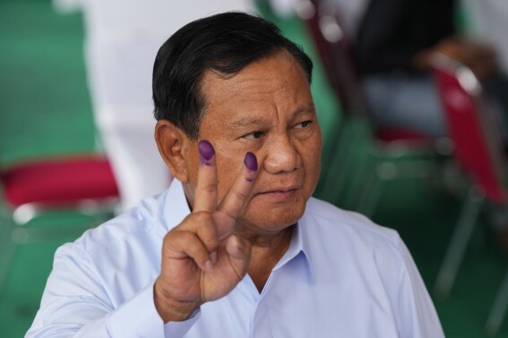FILE - Indonesian presidential candidate Prabowo Subianto displays a victory symbol after casting his vote in Bojong Koneng, Indonesia, Wednesday, Feb. 14, 2024. Subianto’s rise as Indonesia’s apparent next president is a dramatic comeback from a notorious past, which saw the United States banning his entry over human rights and the Indonesian army, where he led the special forces, expelling him.(AP Photo/Vincent Thian, File)