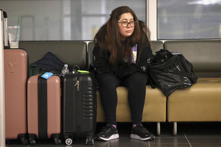 Stephanie Shinn from Kenmore waits three hours at this point while her husband waits in line to rebook their flight to Philadelphia after their flight on Alaska Airlines was canceled at Seattle-Tacoma International Airport on Saturday, Jan. 6, 2024, in SeaTac, Wash. (Karen Ducey/The Seattle Times via AP)
