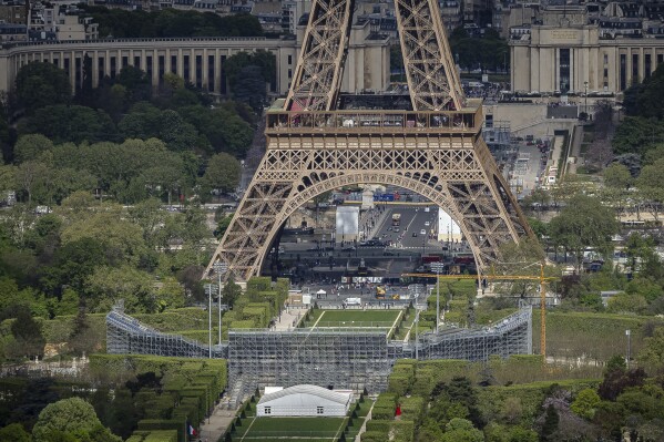 The stands are under construction on Champ-De-Mars, provided, with Eiffel Tower in the background, Monday 15 April 2024 in Paris. The Champ-De-Mars will host the beach volleyball and blind football in the Olympic Games and the Disabled in Paris 2024. (AP Photo/Aurelien Morissard)