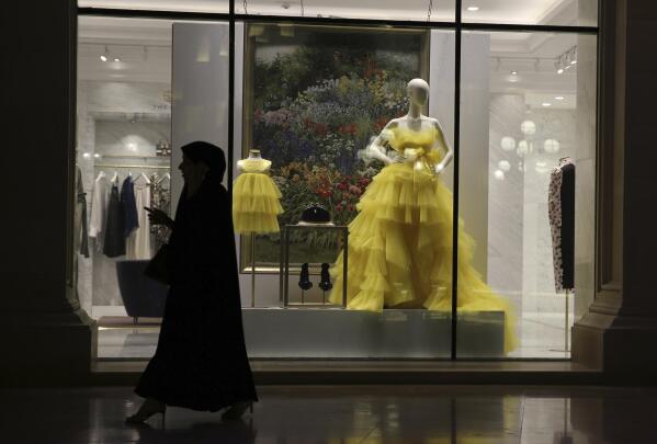 A Muslim lady wearing a Niqab passes the luxury shop window of