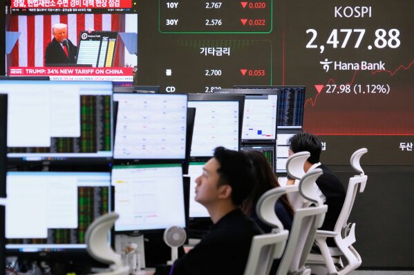 U.S. President Donald Trump is seen on a screen as currency traders work at the foreign exchange dealing room of the KEB Hana Bank headquarters in Seoul, South Korea, Thursday, April 3, 2025. (AP Photo/Ahn Young-joon)
