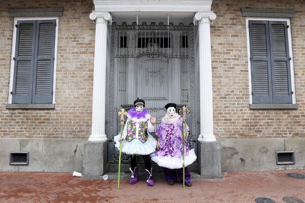 Jeff Thomas e Cellon Bolt encontram um raro local pacífico na Bourbon Street durante as celebrações do Mardi Gra em Nova Orleans, 25 de fevereiro de 2020. (AP Photo/Rusty Costanza, arquivo)