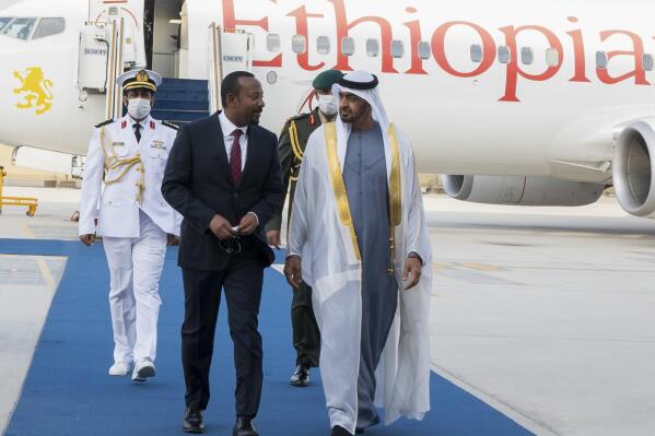 In this photo released by the United Arab Emirates' state-run WAM news agency, Abu Dhabi's powerful crown prince, Sheikh Mohammed bin Zayed Al Nahyan, right, greets Ethiopian Prime Minister Abiy Ahmed after his arrival in Abu Dhabi, United Arab Emirates, Saturday, Jan. 29, 2022. Ahmed is in the United Arab Emirates on a state visit amid his country's ongoing war against Tigray rebels. (Abdulla Al Neyadi/Ministry of Presidential Affairs/WAM via AP)
