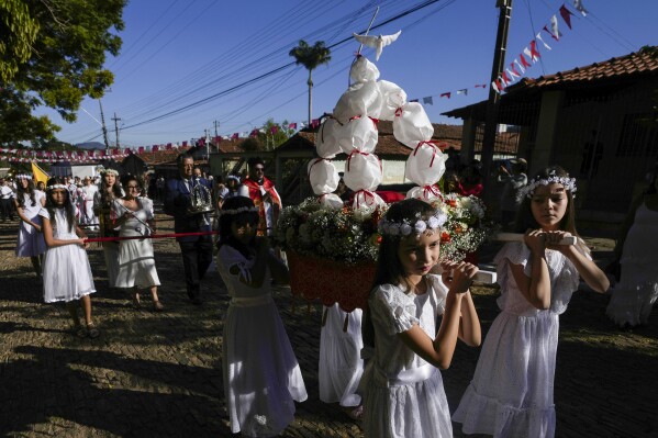 Girls participate in a procession in the Cavalhadas festival in Pirenopolis, Goias, Brazil, Sunday, May 19, 2024. A Portuguese priest brought the tradition to Brazil in the 1800s to celebrate the Holy Spirit and to commemorate the victory of Iberian Christian knights over the Moors. (AP Photo/Eraldo Peres)