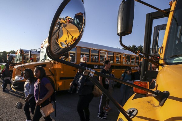 FILE - Jefferson County Public School students transfer buses at the Nichols Bus Compound, Friday, Aug. 18, 2023 in Louisville, Ky. Kentucky's long-running political battle over whether taxpayer money should fund private or charter schools could be settled “once and for all” when voters weigh in decide the issue in November, the state Senate's top Republican leader said Tuesday, April 16, 2024. (Michael Clevenger/Courier Journal via AP, File)