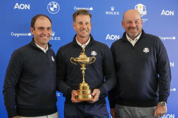 2023 Europe Ryder Cup golf captain Henrik Stenson, center, holds the Ryder Cup trophy as he poses for photos with his vice captains Edoardo Molinari, left, and Thomas Bjorn, at the end of a press conference at the Marco Simone golf club, in Guidonia Montecelio, outskirts of Rome, Monday, May 30, 2022. (AP Photo/Andrew Medichini)