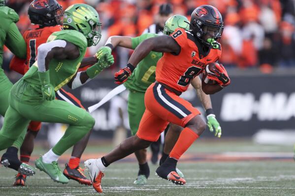 Oregon State running back Jam Griffin (8) rushes as Oregon defensive back Jamal Hill, front left, pursues during the second half of an NCAA college football game on Saturday, Nov 26, 2022, in Corvallis, Ore. (AP Photo/Amanda Loman)